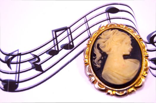 Old brooch on musical notes on a white bottom