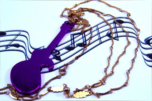 Guitar of mauve color with a chain rests on musical notes.