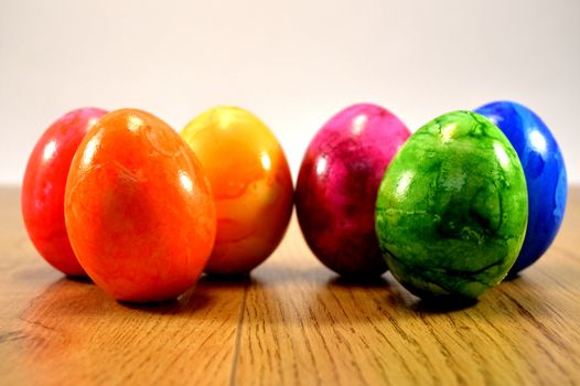 Six eggs of Easter rest up on a wooden ground