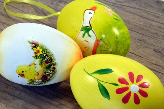 Three Easter eggs painted on a wooden ground