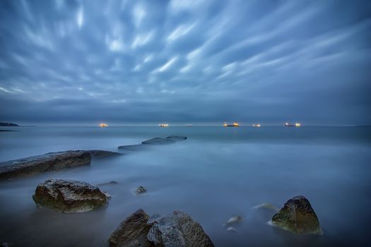 stunning long exposure seascape with on rocks on the beach