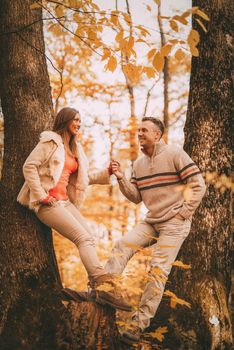 Beautiful lovely couple enjoying in forest in autumn colors.