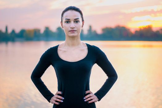 Young pretty woman portrait in early morning at colorful sunrise background