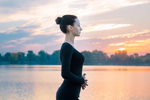 Young pretty woman portrait in early morning at colorful sunrise background