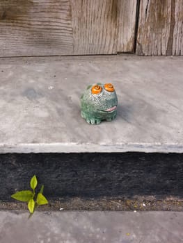 Toy frog sitting on the contry porch