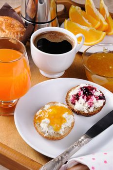 Breakfast of bun with ricotta orange and cherry jam