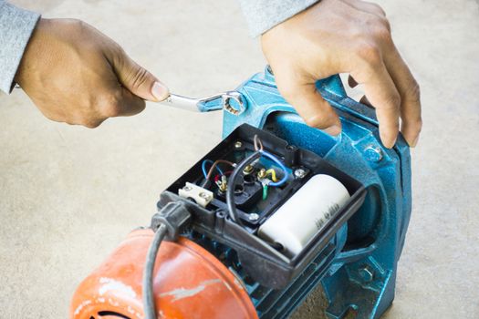 Electric motor  and man working equipment repair on cement floor background.Backgroud motor or equipment.Zoom in