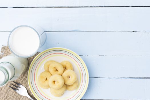 Donut dessert and milk bottle and milk glass  on wooden sky blue table.Meal or breakfast hi-vitamin and calcium.141