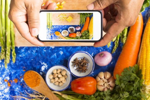 Man taking photo of vegetable with pork or raw food and ingredient on blue background dark tone.Top view.11