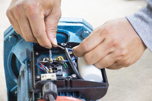 Electric motor  and man working equipment repair on cement floor background.Background motor or equipment.Close up.0011