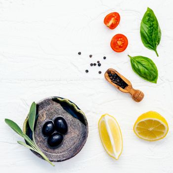 Food background with fresh herbs  tomato ,lemon slice , black pepper ,sage leaves ,sweet basil and olive oil over white wooden background  with flat lay and copy space.