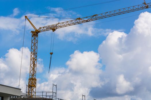 Construction crane against blue sky photographed, space for labeling.