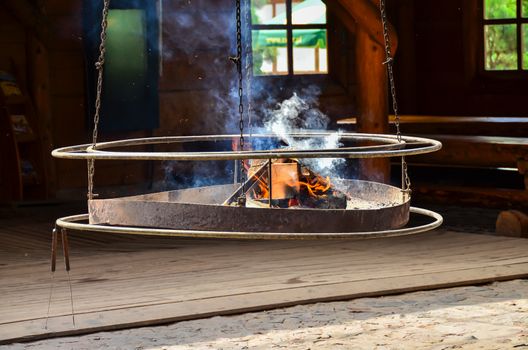 Image of a hanging grill with the fire ready for barbecue
