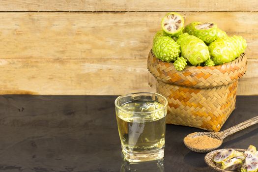 Noni fruit  and noni juice with noni powder on black table.Fruit for health and herb for health.11121