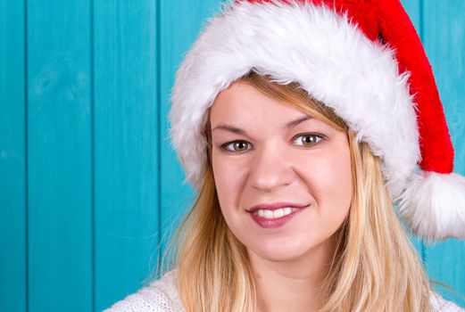 Beautiful woman in Christmas cap. blue background