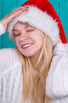 Beautiful woman in Christmas cap. blue background