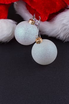 Christmas baubles and Santa hat, black background