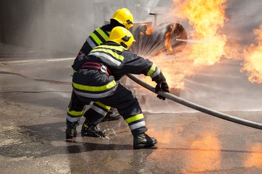 Firefighters attack a propane fire during a training exercise