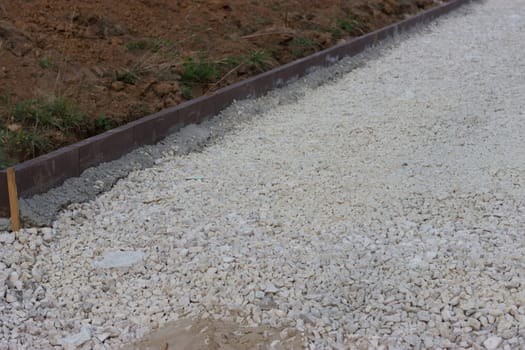 incomplete road with white gravel  in the forest