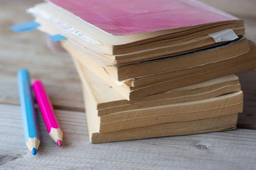 stack of books with yellow paper and pencils