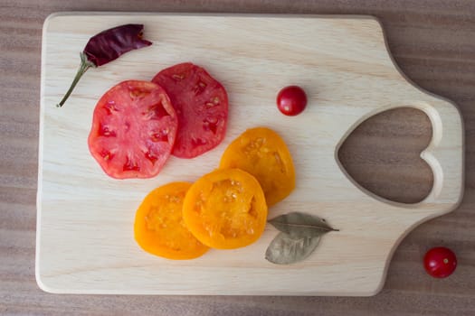 carving bord with red and yellow tomato
