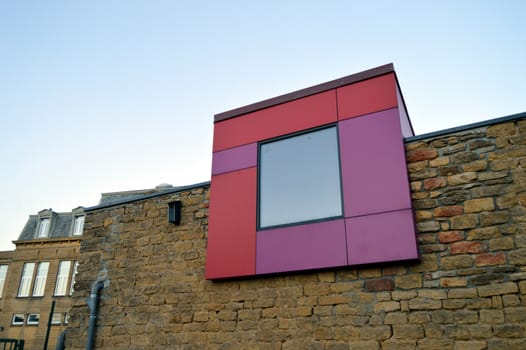 Modern box of turquoise blue color rest on an old stony wall