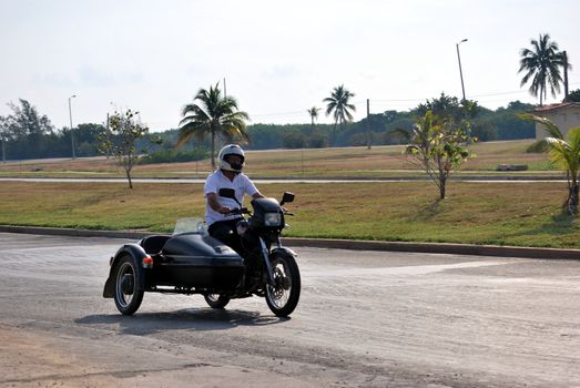 Old sidecar black on a road in Cuba