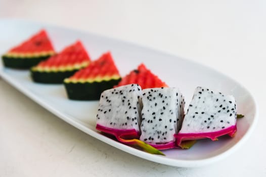 sliced dragon fruit and watermelon on plate, selective focus