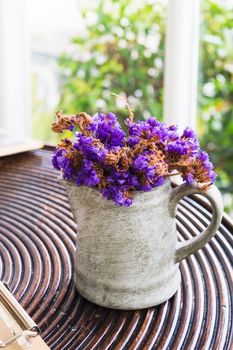 dried purple flower in pot on wooden table