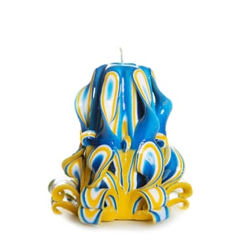 Carved colored candle isolated on white background