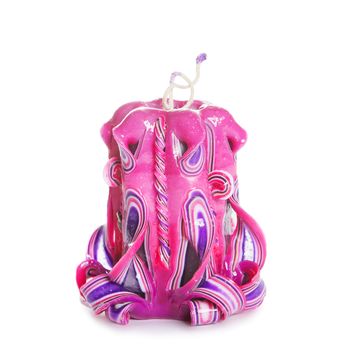 Carved colored candle isolated on white background