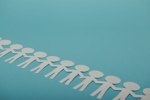 abstract paper people holding for hands on blue background