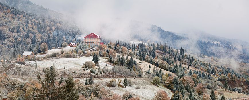 Hotel in mountains. Snow and fog. First snow in autumn. Snowfall in mountains