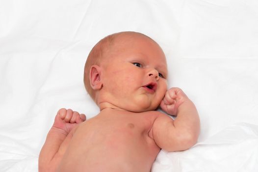 Close up shot of boy newborn jaundice lying on white bed sheet