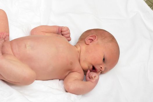 Close up shot of boy newborn jaundice lying on white bed sheet