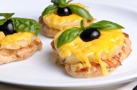 pieces of chicken fillet    a slice of pineapple with cheese