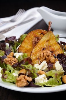 Salad of lettuce with   walnuts, cashews, slices  feta,  halves of caramelized pear