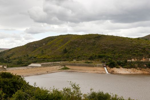 Low Water levels at the Loerie Dam on a cloudy day.