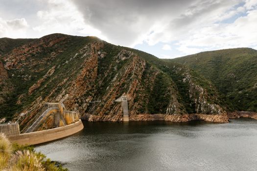 Low water level at the Kouga Dam with storm clouds approaching.