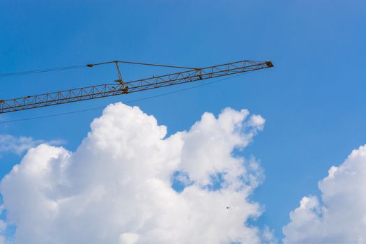 Construction machinery at a construction site in the background a blue sky.