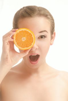 Surprised beautiful young woman holding a slice of orange in front of my eyes. White background