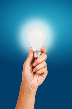 energy saving lamp in hand on blue background