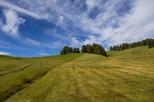 panoramic view of the Seiser Alm in a sunny day with blue sky and clouds