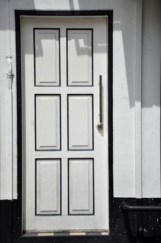 White wall with white door with black frame