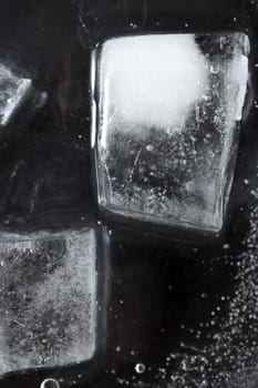 Black frozen water surface with ice cubes