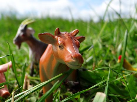 Miniature toy of farm animals in the grass