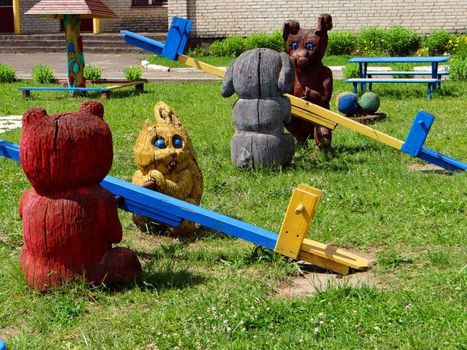 Children's playground with wooden swings and funny animals