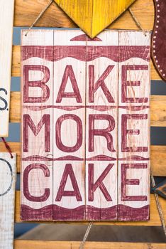 wooden board with the inscription 'Bake more cake'