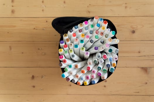 Set of markers on old wooden table - top view