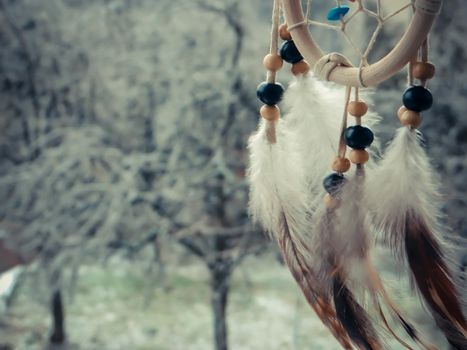 Photo of dream catcher on a winter forest